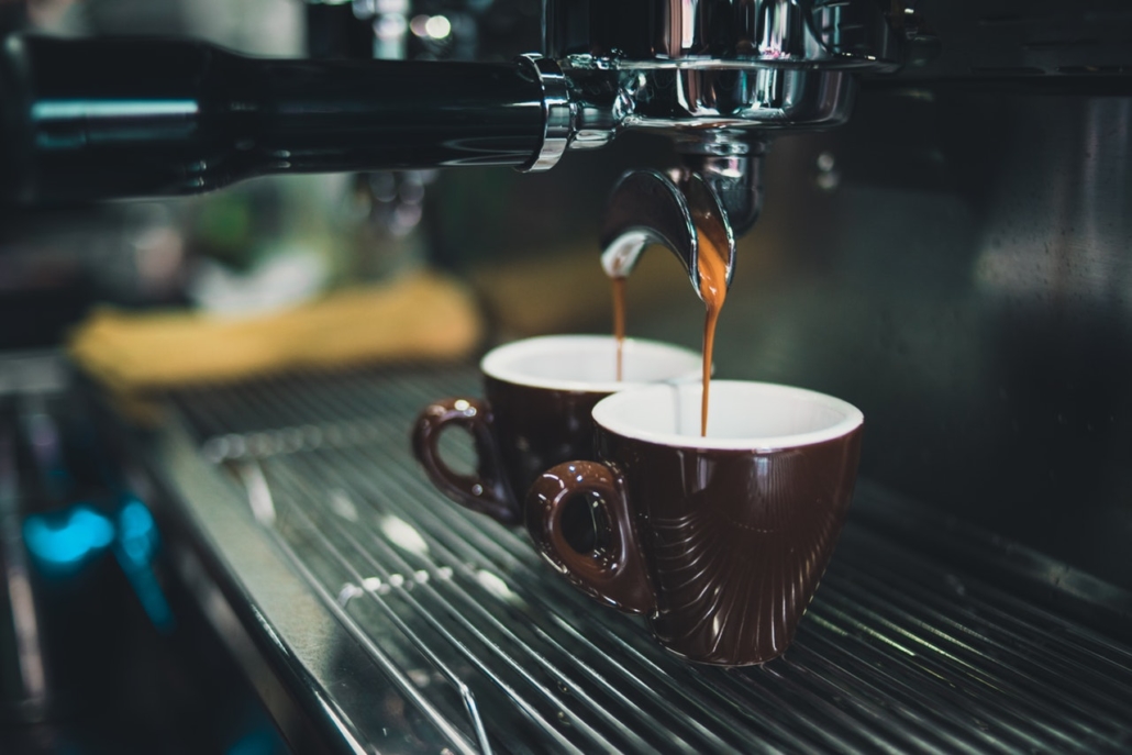 Two Cups of Coffee At Coffee Maker, Currently Brewing a New Batch