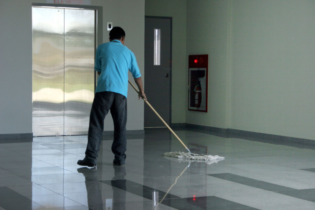 Janitor Mopping The Floor Outside of an Elevator in an Office Building
