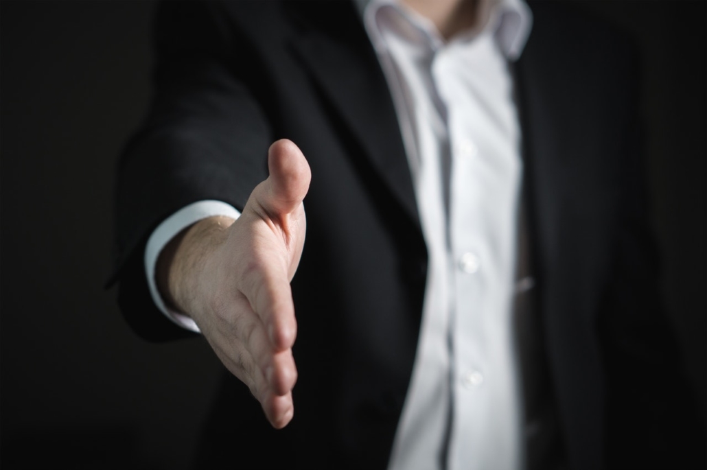 Man In a Black Suit, Reaching Out for a Handshake