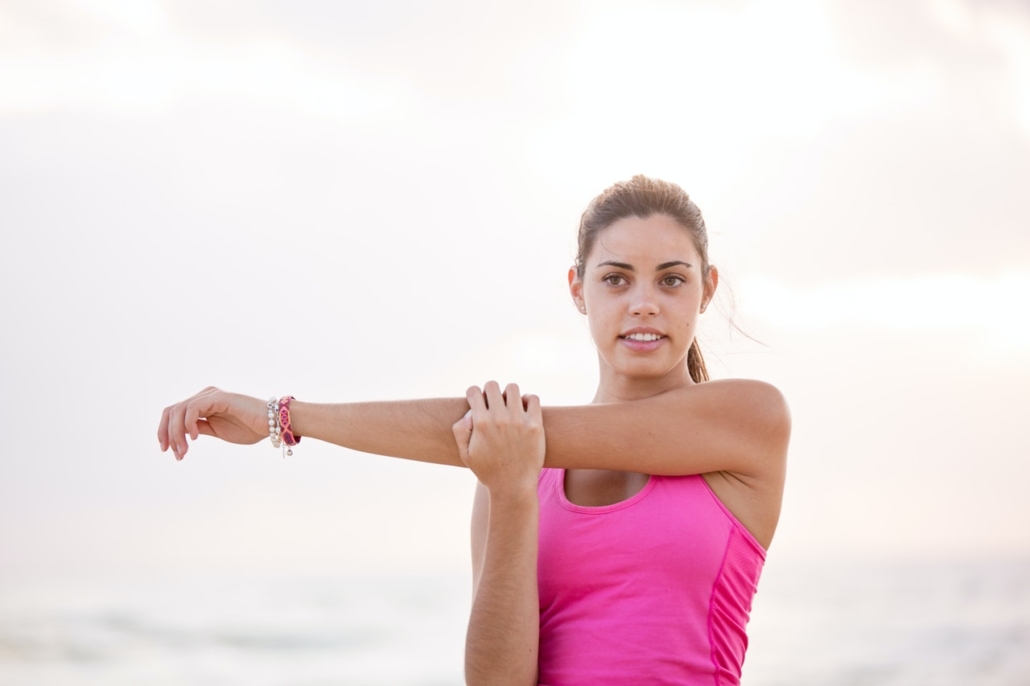 Woman in Pink Shirt Doing Arm Stretches