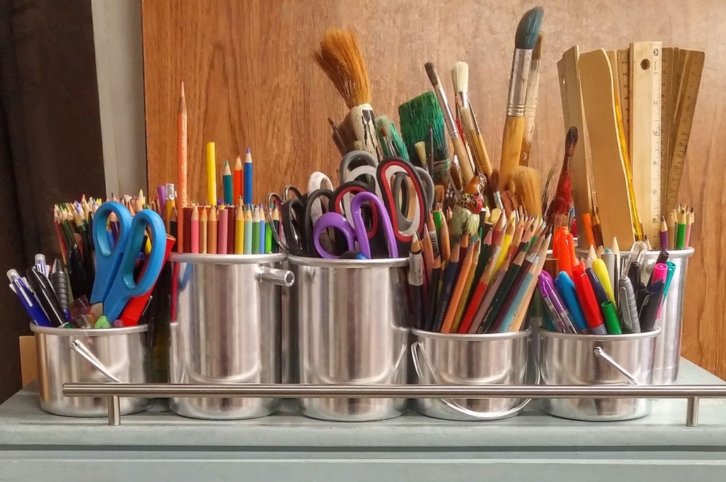Silver Containers Holding Pencils, Scissors, & More