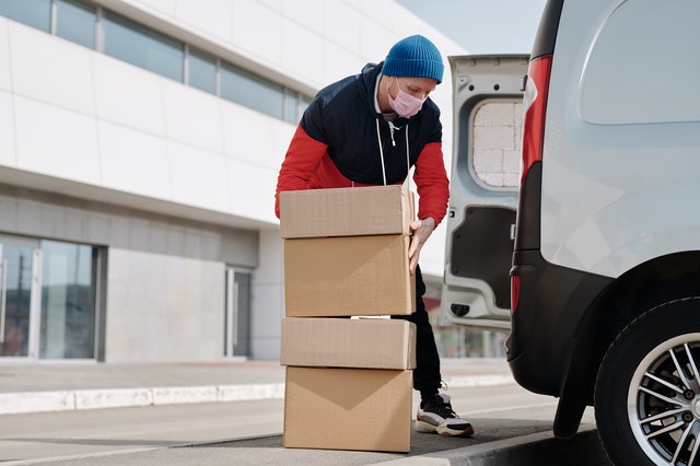 man picking up boxes to put in a truck