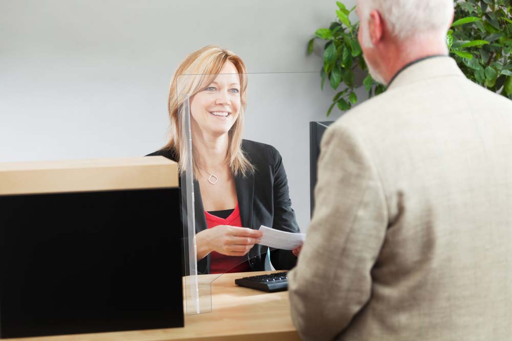 woman at desk behind barrier