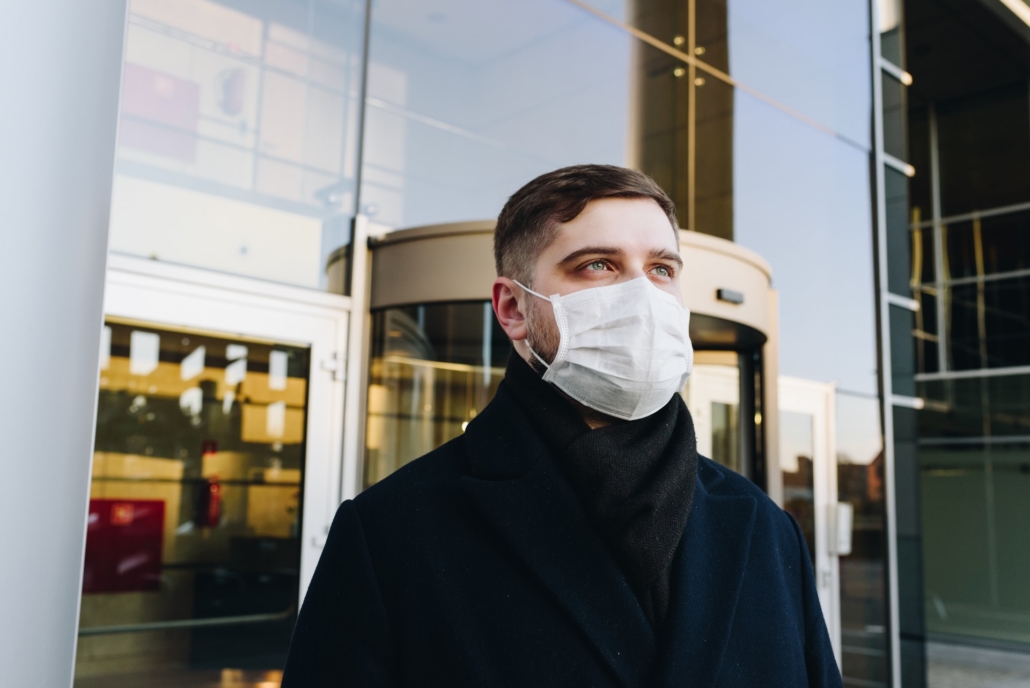 man wearing a mask outside of a building