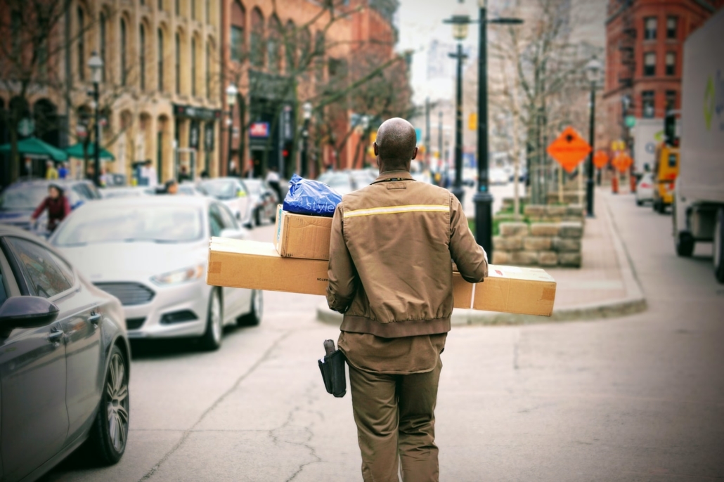 Delivery Man walking down the street with boxes from the back