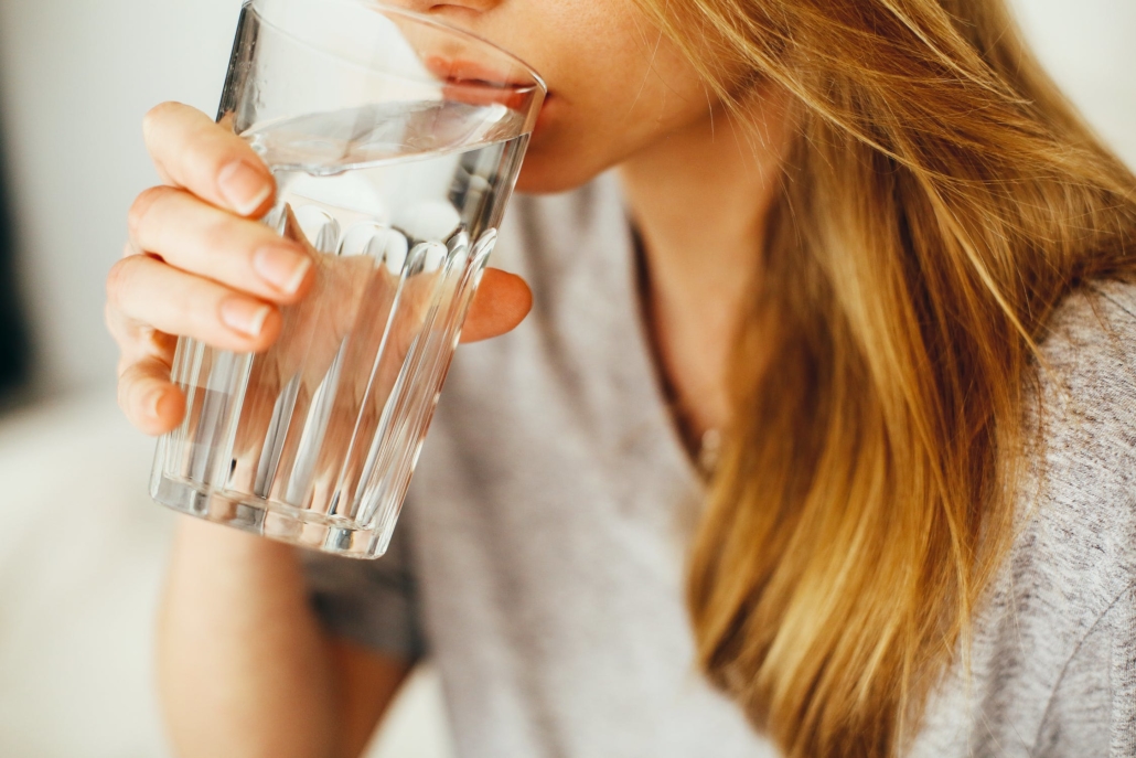 Close-up on a girl drinking clear water in a glass