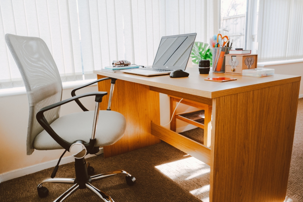 Someone's personal desk and swivel chair at the office, laptop open